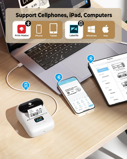 On the desk are a laptop, smartphone, and tablet running label software. A Phomemo M110 Portable Label Printer (White) is connected via Bluetooth, highlighting its seamless multi-device support and compatibility.